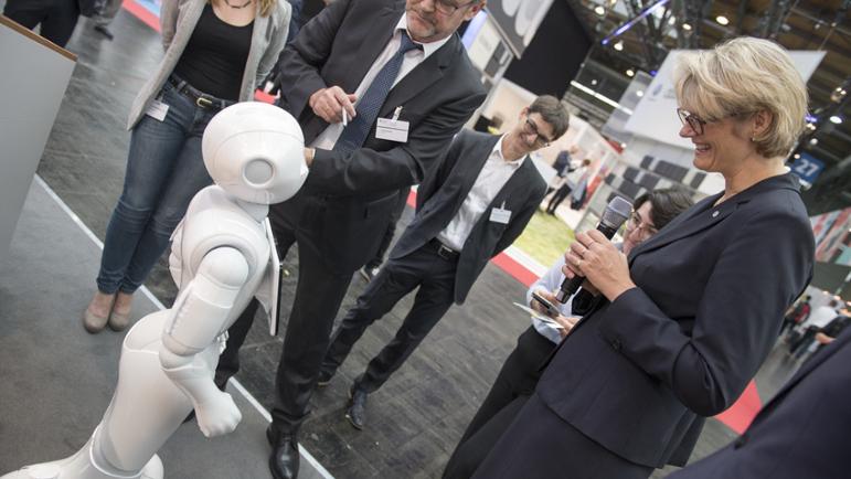 Bundesministerin Anja Karliczek mit Pepper auf dem Stand des BMBF.