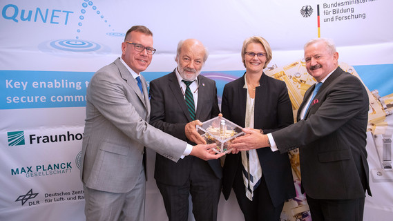 Prof. Dr. Andreas Tünnermann, Institutsleiter am Fraunhofer IOF, Prof. Dr. Gerd Leuchs, Direktor am Max-Planck-Institut für die Physik des Lichts, Bundesministerin Anja Karliczek und Fraunhofer-Präsident Prof. Dr. Reimund Neugebauer mit einer verschränkte